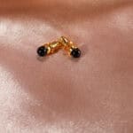 Close-up showing raw or polished black tourmaline set in gold posts