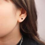 Model wearing black tourmaline mini studs, showing dainty size and contrast