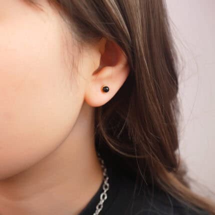 Model wearing black tourmaline mini studs, showing dainty size and contrast