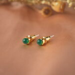 Close-up of polished green agate stone set in small stud posts
