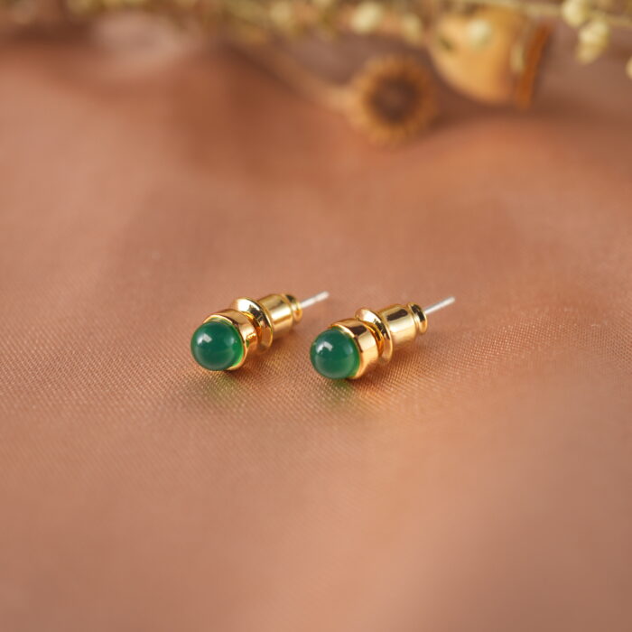 Close-up of polished green agate stone set in small stud posts