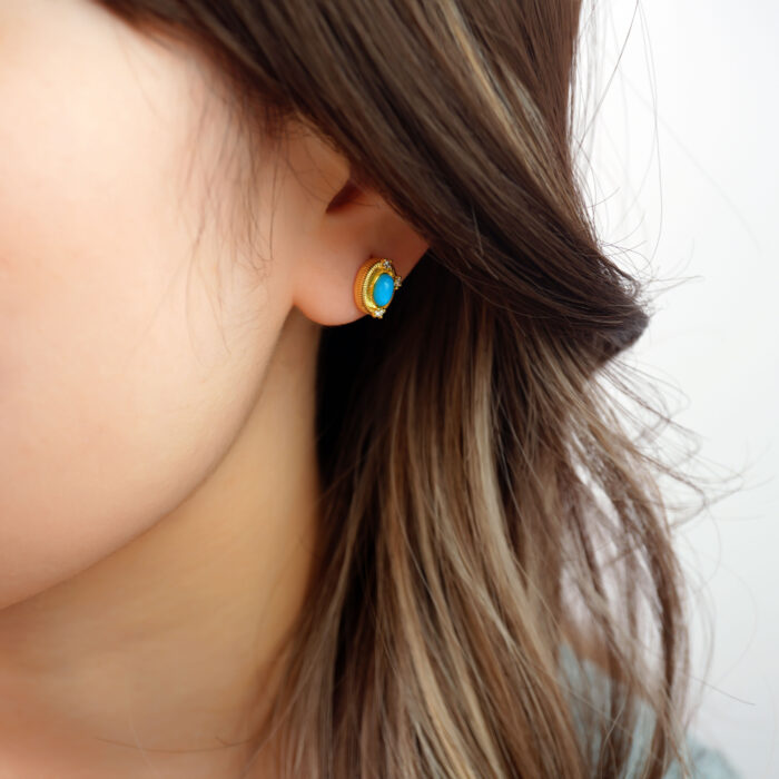 Model wearing the turquoise studs, showing size and warm-toned contrast