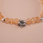 Close-up of small citrine beads and silver flower charm details