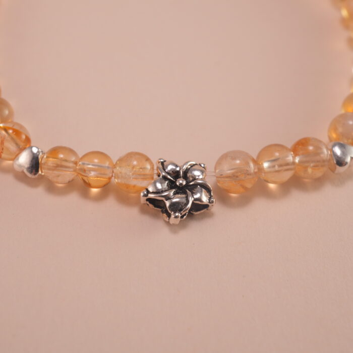 Close-up of small citrine beads and silver flower charm details