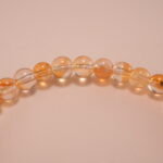 Close-up of small citrine beads and silver flower charm details