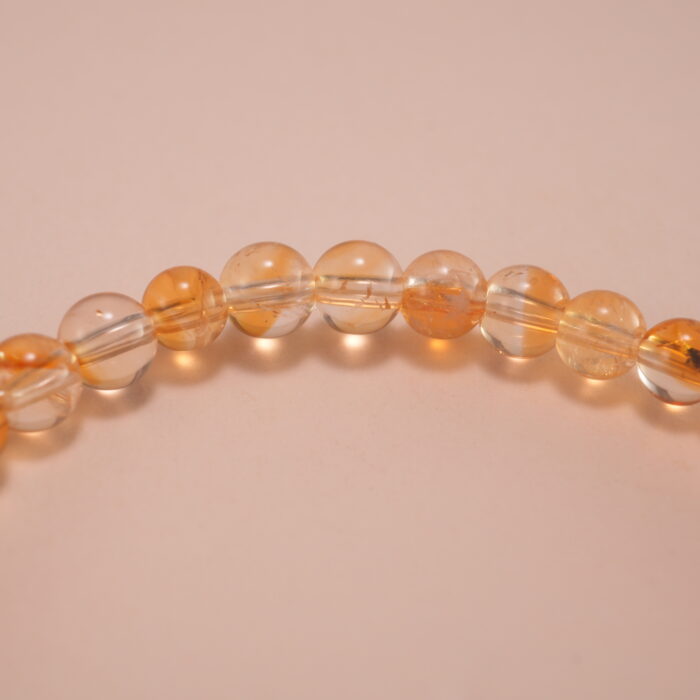 Close-up of small citrine beads and silver flower charm details