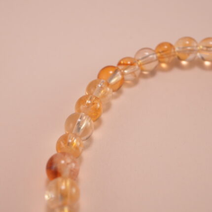 Close-up of small citrine beads and silver flower charm details