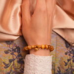 Citrine and Tiger Eye gold charm bracelet elegantly worn on wrist