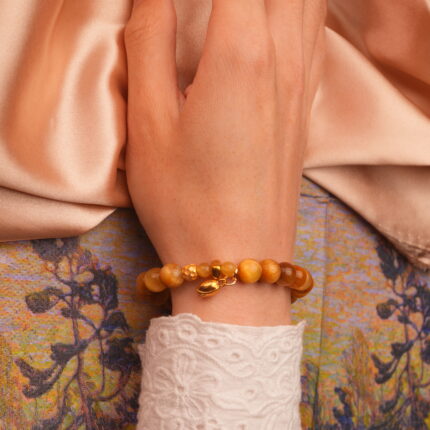 Citrine and Tiger Eye gold charm bracelet elegantly worn on wrist