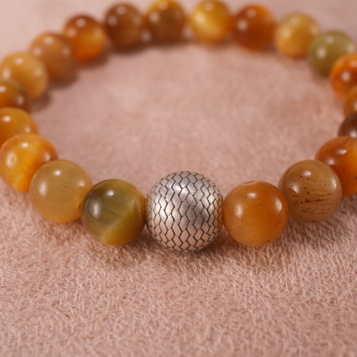 Close-up of polished Tiger Eye beads and silver accent