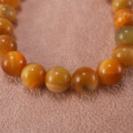 Close-up of polished Tiger Eye beads and silver accent