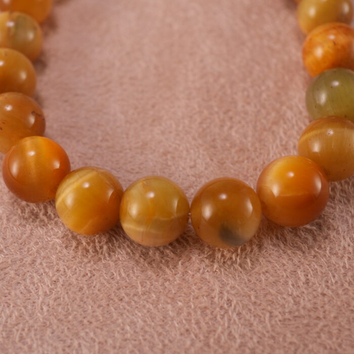 Close-up of polished Tiger Eye beads and silver accent