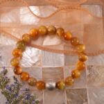 Tiger Eye bracelet placed beside natural stones and sunlight