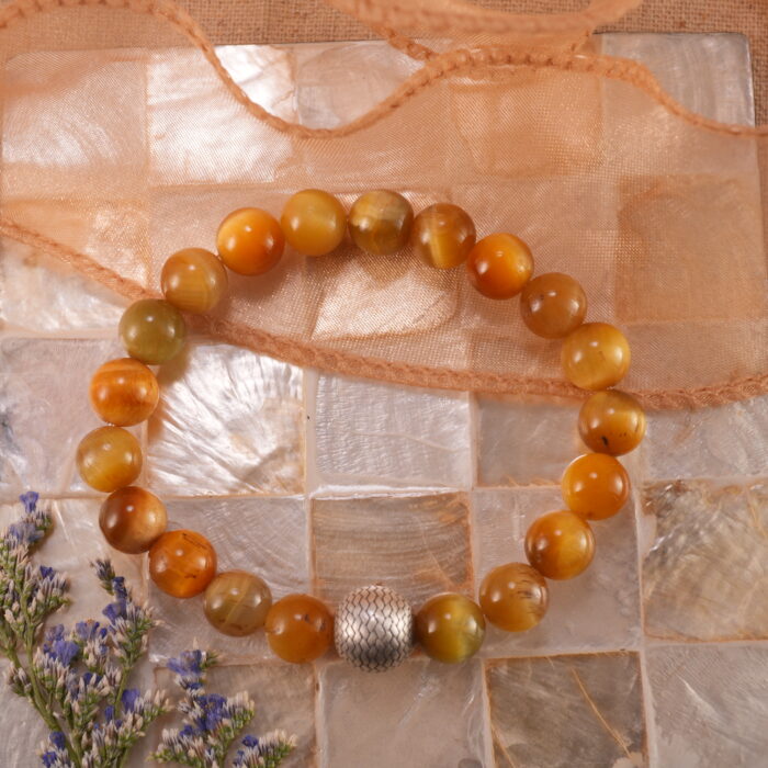 Tiger Eye bracelet placed beside natural stones and sunlight