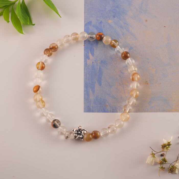 Bracelet displayed beside golden decor and soft white elements