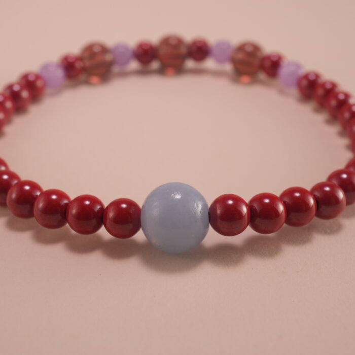 Close-up of rich red cinnabar beads with intricate carving details
