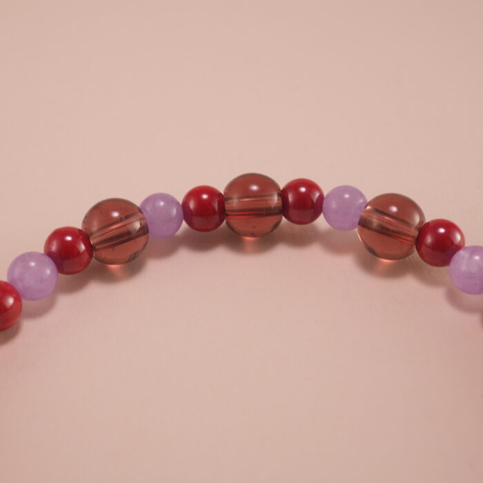 Close-up of rich red cinnabar beads with intricate carving details