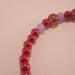 Close-up of rich red cinnabar beads with intricate carving details