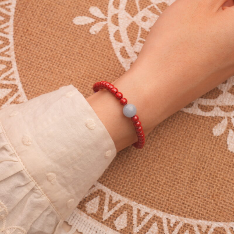 Model wearing cinnabar bracelet – bold red tones enhancing wrist style