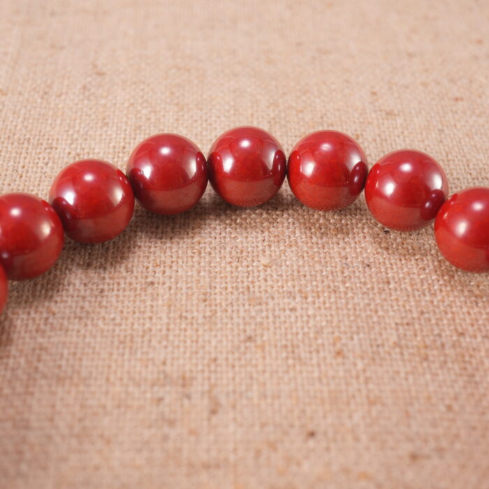Close-up of cinnabar bead carvings and stringing details