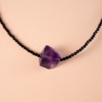 Close-up of faceted amethyst and tourmaline beads or stones in a minimal setting