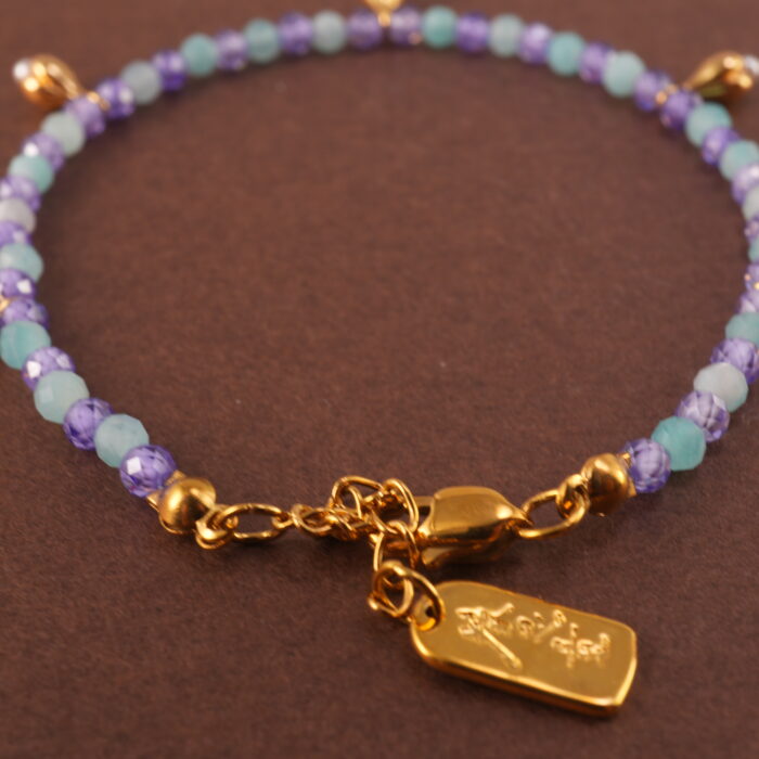 Close-up of aquamarine, amethyst, and pearl beads on adjustable bracelet