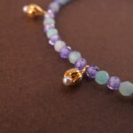 Close-up of aquamarine, amethyst, and pearl beads on adjustable bracelet