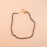 Dainty black tourmaline and obsidian necklace on a neutral or white background