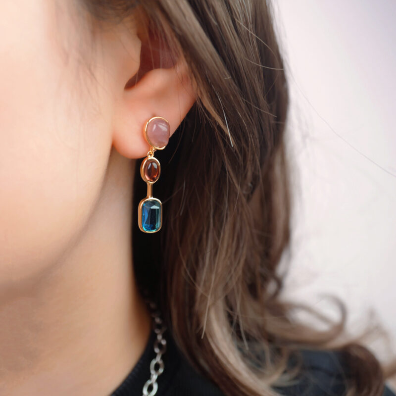 Model wearing the earrings, showing their length and movement