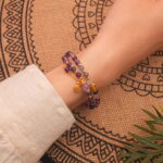 Close-up of amethyst double wrap bracelet worn on wrist showing adjustable fit and polished beads