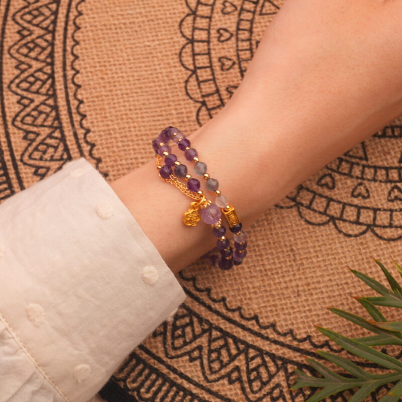 Close-up of amethyst double wrap bracelet worn on wrist showing adjustable fit and polished beads