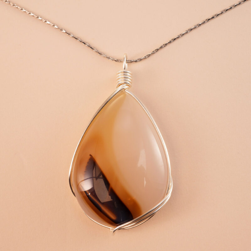 Handcrafted agate teardrop pendant necklace on a neutral or nature-inspired background