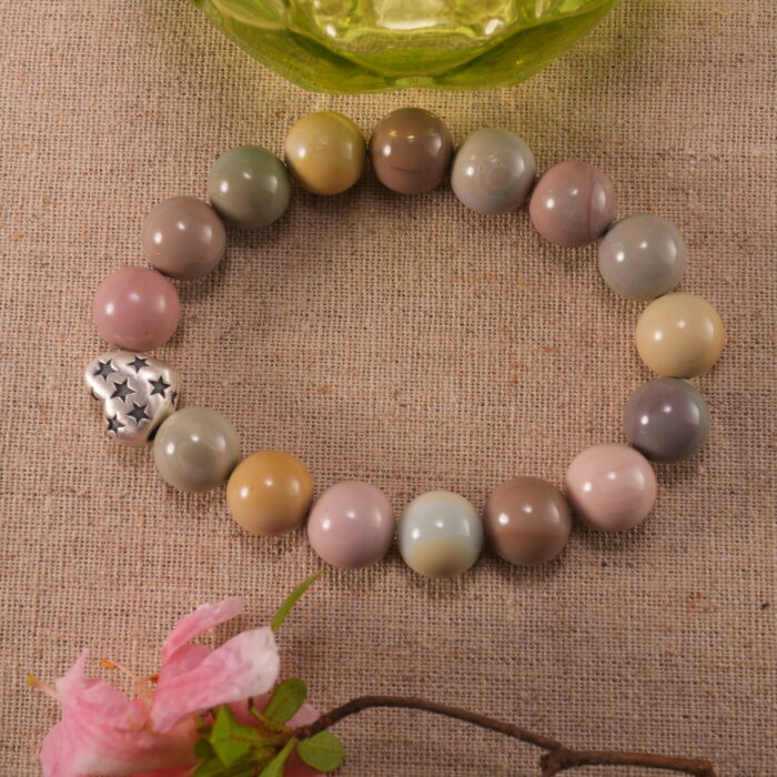 Heart-shaped bracelet placed next to blooming flowers – romantic and elegant handcrafted jewelry setting