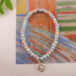 A peaceful scene featuring the Alashan stone beaded bracelet placed on a surface surrounded by calming elements