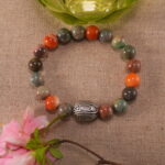 Beaded Alashan stone bracelet beside flowers – calm and grounding jewelry setting