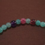 Close-up of Amazonite, Amethyst, Rhodochrosite, and Garnet Beads on Charm Bracelet