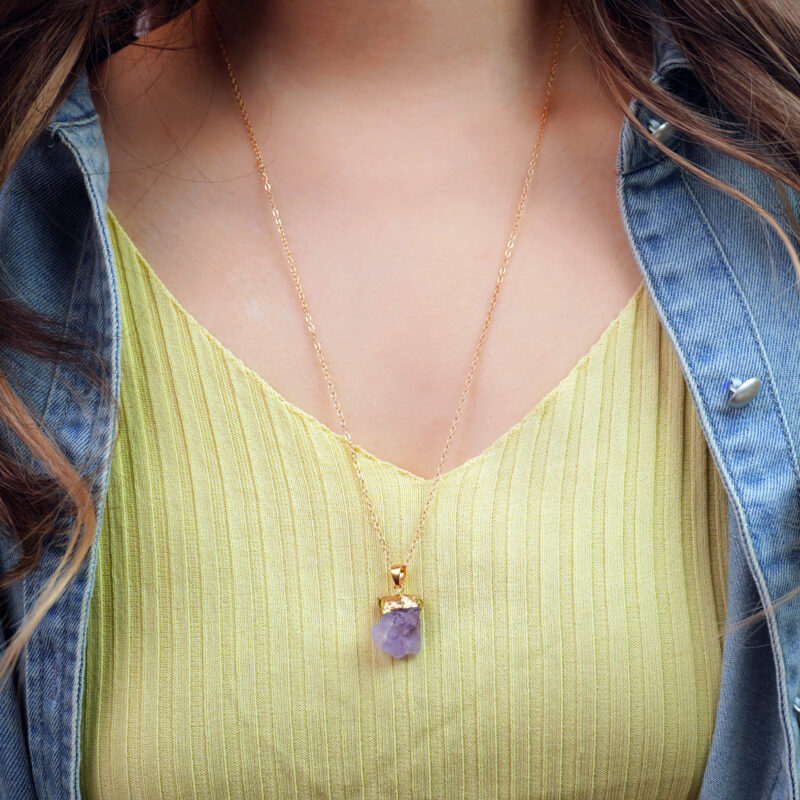 Model wearing handmade amethyst pendant at the heart chakra area