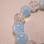 Close-up of Aquamarine and Clear Quartz Beads with Oxidized Flower Charm