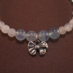 Close-up of Aquamarine Beads, Chalcedony Stones, and Silver Bow Charm