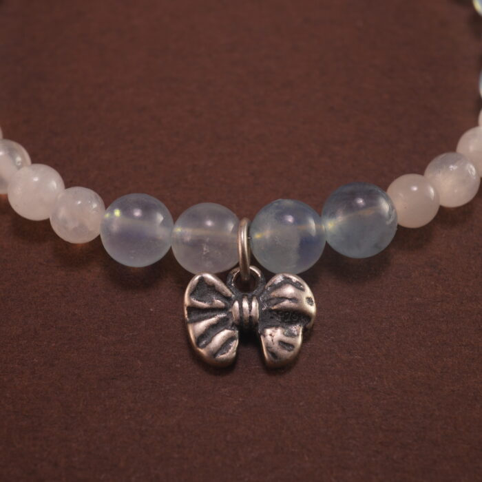 Close-up of Aquamarine Beads, Chalcedony Stones, and Silver Bow Charm