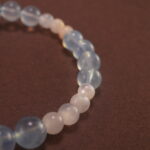 Close-up of Aquamarine Beads, Chalcedony Stones, and Silver Bow Charm