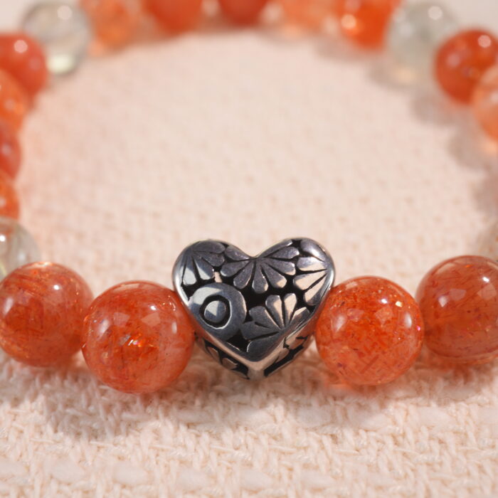 Close-up of 8mm rutile quartz beads with golden threads and heart motif
