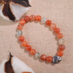 Rutile quartz heart bracelet placed beside soft florals – elegant and energizing