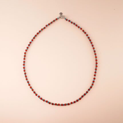 Handmade blue apatite and red agate bead necklace displayed on light background