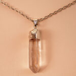Close-up of transparent quartz point with natural inclusions and handmade wrapping