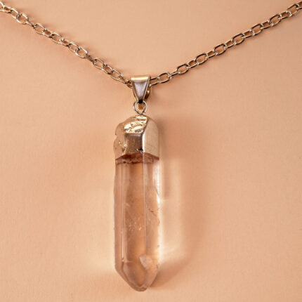 Close-up of transparent quartz point with natural inclusions and handmade wrapping