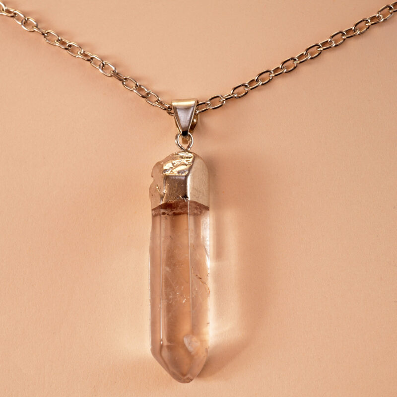 Close-up of transparent quartz point with natural inclusions and handmade wrapping