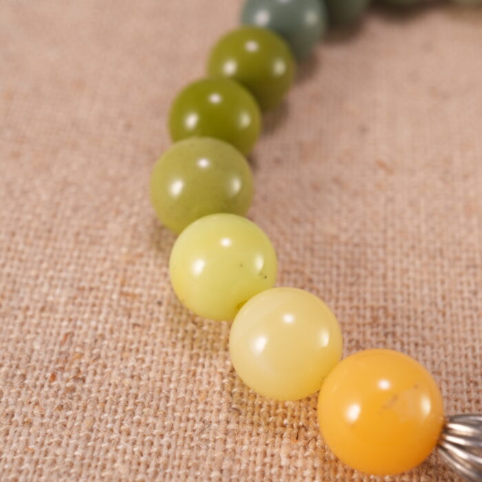 Close-up of flower charm on beaded bracelet, showcasing intricate craftsmanship