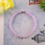 Amethyst bracelet placed beside a lavender candle and journal, evoking a calming bedtime ritual