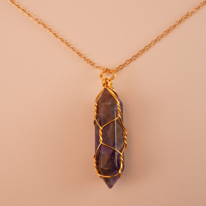 Close-up of dream amethyst’s banded purple & white patterns in a polished point